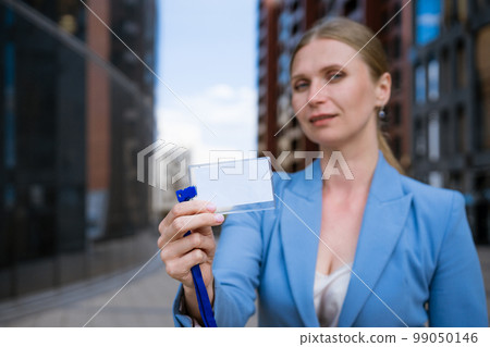Business woman holding badge in hand 99050146