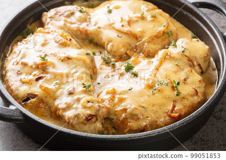 Homemade Smothered Bone-In Pork Chops in creamy onion gravy closeup on the pan. Horizontal 99051853
