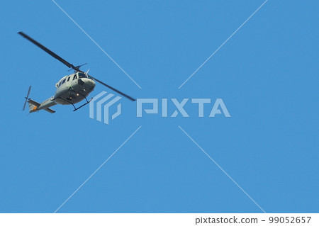 Close-up photo of a helicopter flying in the blue sky 99052657
