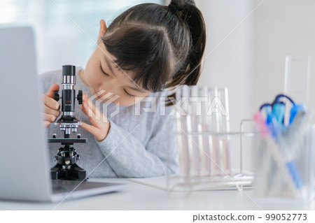 Elementary school girl looking into a microscope 99052773