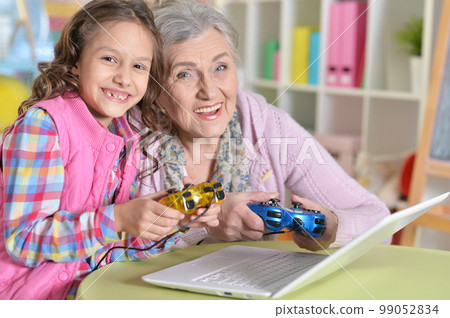 Cute girl and grandmother playing 99052834