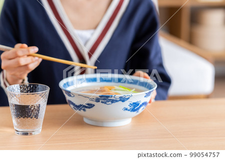 young woman eating ramen 99054757