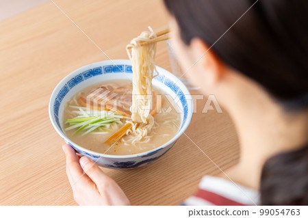 young woman eating ramen 99054763