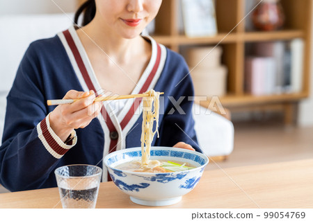 young woman eating ramen 99054769