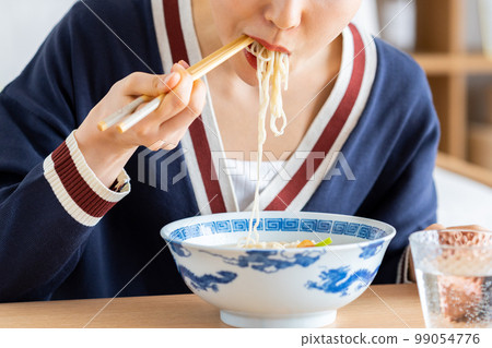 young woman eating ramen 99054776