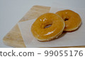Glazed donuts on a wooden board 99055176