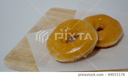 Glazed donuts on a wooden board 99055176