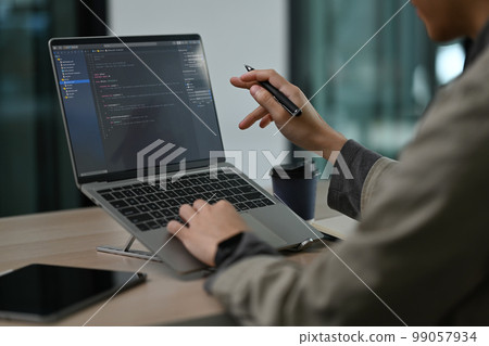 Cropped view of professional software developer working with coded data in bright modern office 99057934