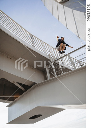 Man doing huge parkour jump from the bridge Man doing huge parkour jump from the bridge 99058198