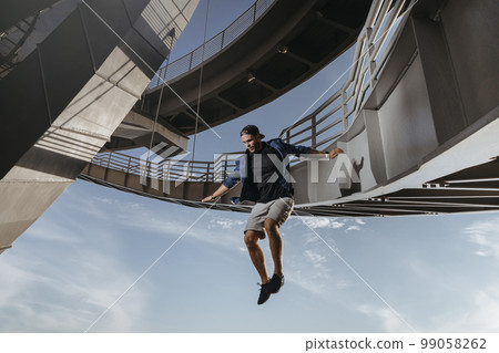 Huge and risky jump from a bridge performed by parkour athlete Huge and risky jump from a bridge performed by parkour athlete 99058262