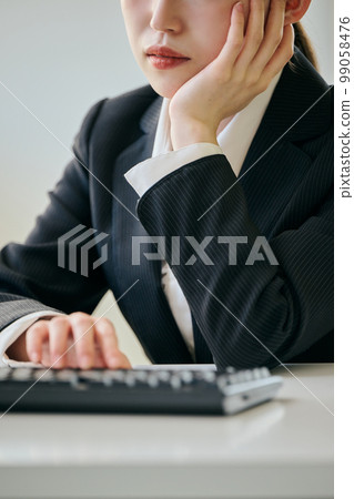 Young woman with a gloomy look at her desk Young woman with a gloomy look at her desk 99058476