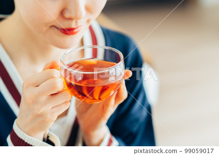 A young woman who drinks tea 99059017