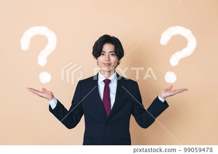 Young businessman comparing two 99059478