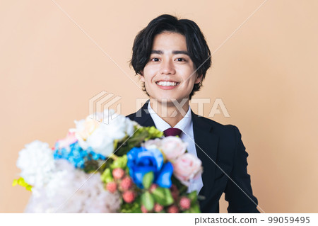 一個穿著西裝的男人拿著一束鮮花 一個穿著西裝的男人拿著一束鮮花 99059495