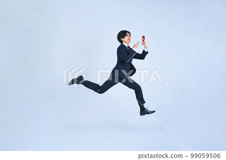 一個男人在使用智能手機時跳躍 99059506