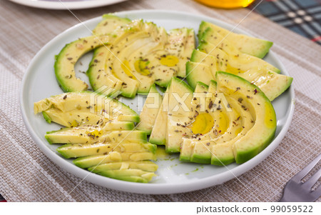 ripe avocado pulp cut into pieces sprinkled with lemon juice on a plate 99059522