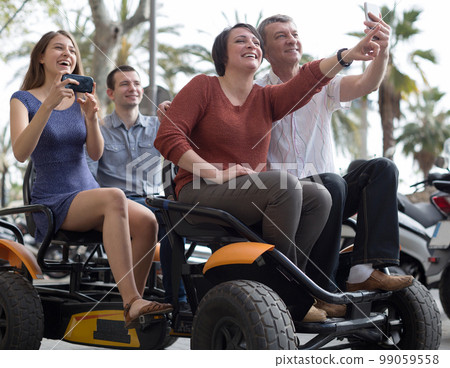family of tourists enjoy a walk on the bike carriage family of tourists enjoy a walk on the bike carriage 99059558