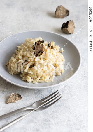 Risotto with porcini mushrooms and black truffles served in a plate top view, gourmet cousine 99060994