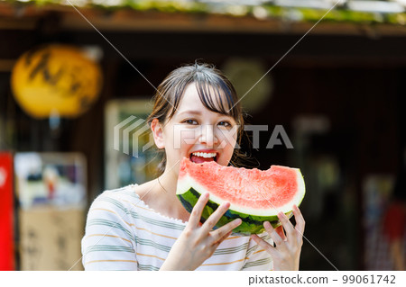 在旅遊商店吃西瓜的年輕女子 在旅遊商店吃西瓜的年輕女子 99061742