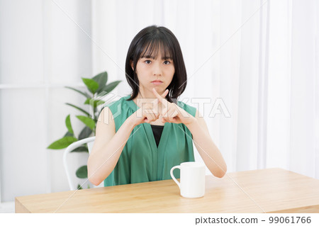 一名年輕女子在客廳裡表現出 NG 標誌 99061766