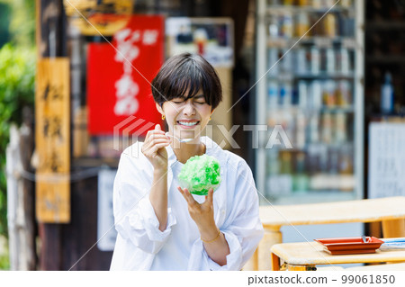 在旅遊景點吃刨冰的年輕女子 在旅遊景點吃刨冰的年輕女子 99061850