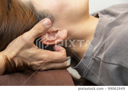 A woman receiving massage (bodywork, pelvic correction) 99062649