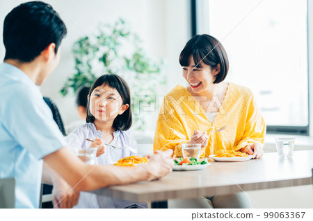 Parents and children having lunch at a restaurant 99063367