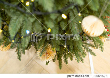 Decorated Christmas Tree, Christmas Decorations, Shiny Garland on Green Branches, Blurred Background Decorated Christmas Tree, Christmas Decorations, Shiny Garland on Green Branches, Blurred Background 99064825
