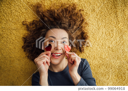 Funny girl sticks her tongue out, flirts with hearts on her cheeks Funny girl sticks her tongue out, flirts with hearts on her cheeks 99064918
