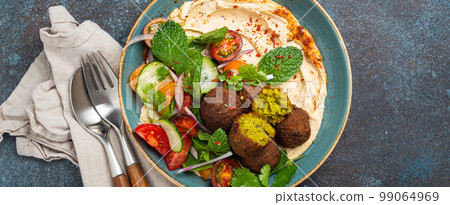 Middle Eastern Arab meal with fried falafel, hummus, vegetables salad 99064969