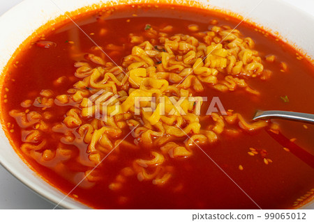Red Spicy Noodle Soup in White Bowl, Hot Chili Pepper Ramen Closeup Red Spicy Noodle Soup in White Bowl, Hot Chili Pepper Ramen Closeup 99065012