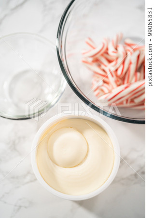 Measured ingredients in a glass mixing bowl to prepare peppermint buttercream frosting. 99065831