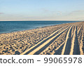 Sea coast. Wheel ruts on the sand. 99065978
