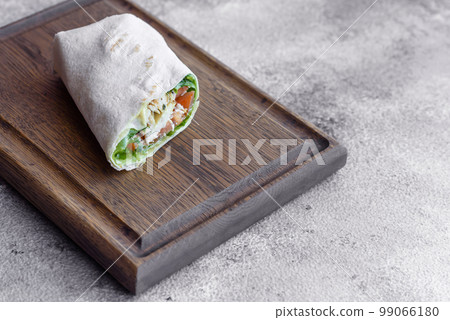Delicious fresh roll with chicken, tomatoes, lettuce and cucumber in pita bread 99066180