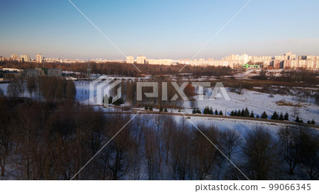 A winding bike path in a city park. City park in winter. Snow lies on the ground. Aerial photography. 99066345
