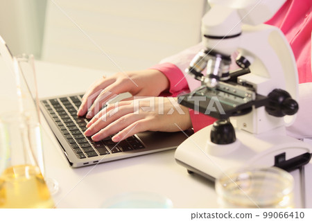 Female scientist working at laptop computer in research laboratory. 99066410