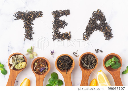 Various tea in wooden spoons. Black, green rooibus and herbal tea. Top view 99067107