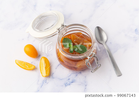 Delicious kumquat jam in glass jar with mint 99067143