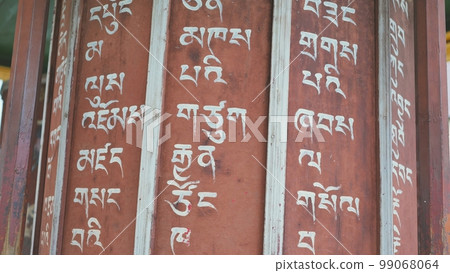 Rotation of the prayer drums outside the Buddhist temple. 99068064