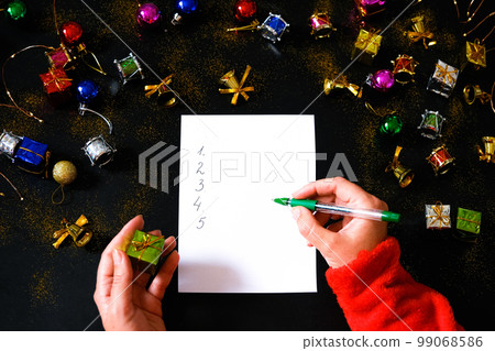 Hands writing on paper list of New Year resolutions. Hands writing on paper list of New Year resolutions. 99068586