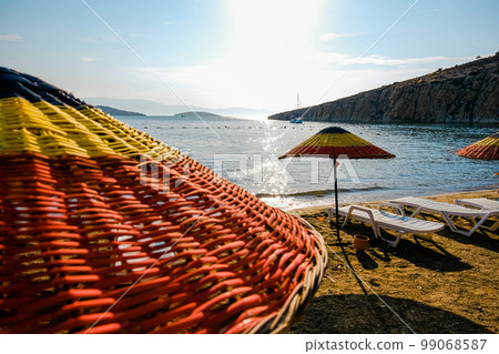 Colorful straw beach umbrellas at the seaside. Colorful straw beach umbrellas at the seaside. 99068587