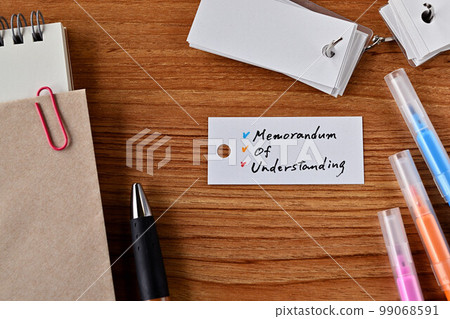 A desk with a vocabulary notebook labeled Memorandum Of Understanding A desk with a vocabulary notebook labeled Memorandum Of Understanding 99068591