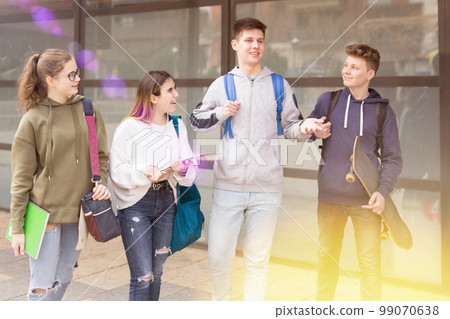 Carefree teen students walking outside school Carefree teen students walking outside school 99070638
