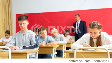 Teacher communicates freely with students in classroom at school Teacher communicates freely with students in classroom at school 99070845