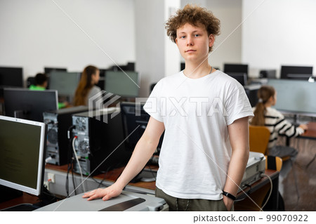 Teenager boy standing in computer class 99070922