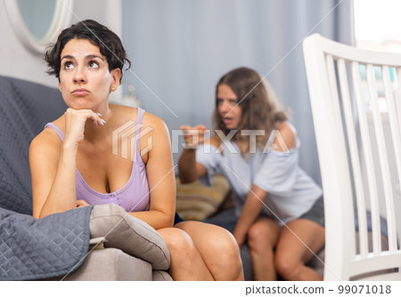 Offended young woman pursed her lips during quarrel with her girlfriend Offended young woman pursed her lips during quarrel with her girlfriend 99071018