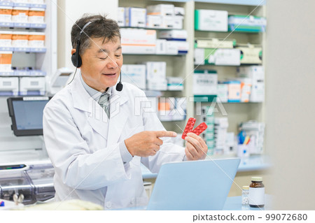 在醫院/藥房使用計算機提供在線用藥指導/醫療的男性藥劑師/配藥員（處方/醫生） 99072680