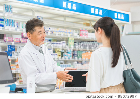 Pharmacist explaining using a tablet PC at a pharmacy, hospital, drug store (prescription, medicine, supplement) Pharmacist explaining using a tablet PC at a pharmacy, hospital, drug store (prescription, medicine, supplement) 99072997