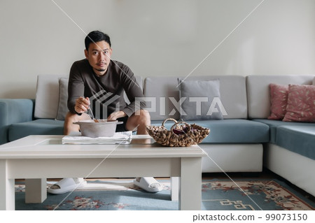 Lonely man having a meal alone in his home. Lonely man having a meal alone in his home. 99073150