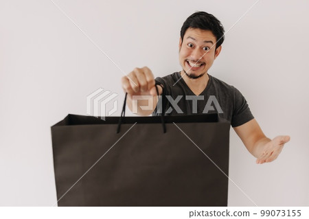 Funny Asian man face who buy a nice product in the bag. Funny Asian man face who buy a nice product in the bag. 99073155